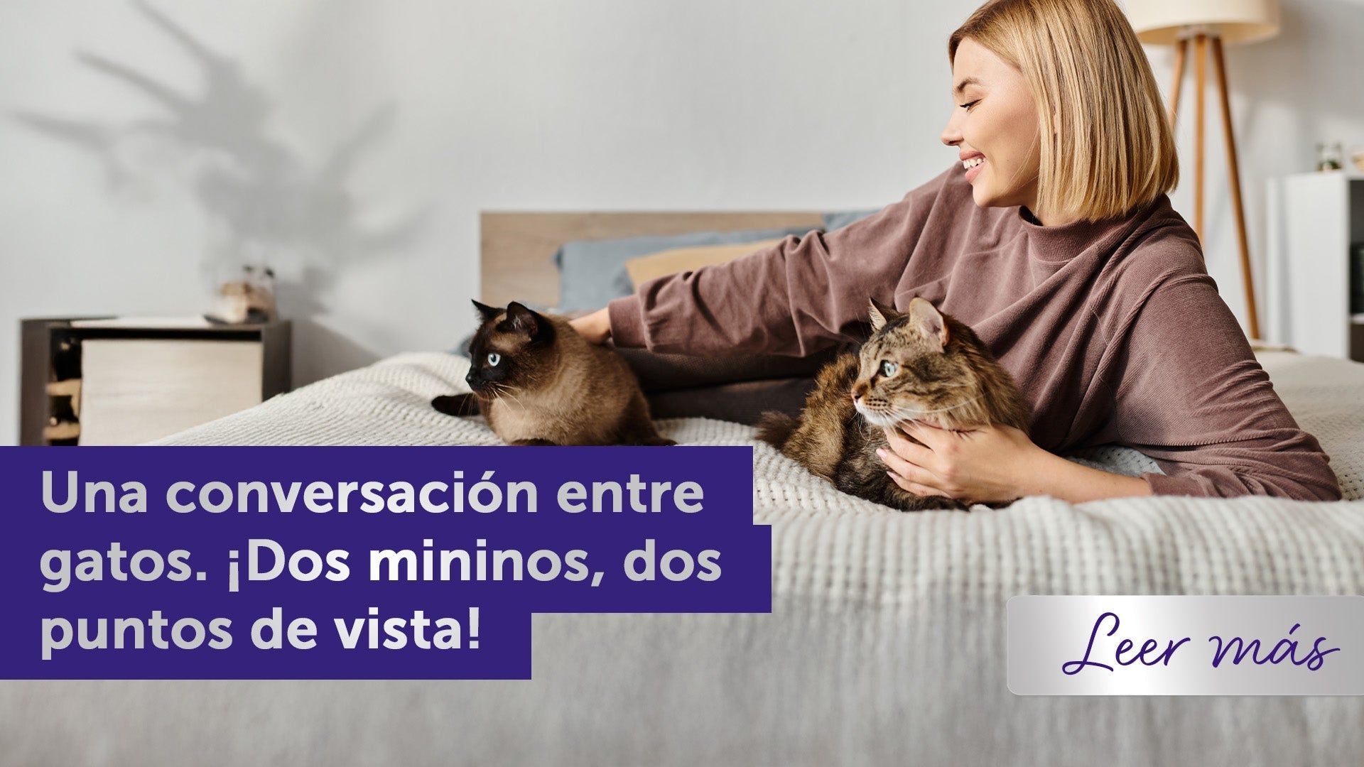 Joven recostada en la cama con dos gatos.